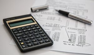 a calculator on a desk running financial numbers - How can Equity help a Household
