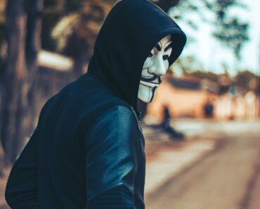 person wearing mask and hoodie - Tips For Avoiding Frauds and Scams