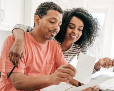 black couple at a desk working on finance planning - Learn How to Finance Your Home Renovations the Right Way with RenFi Capital